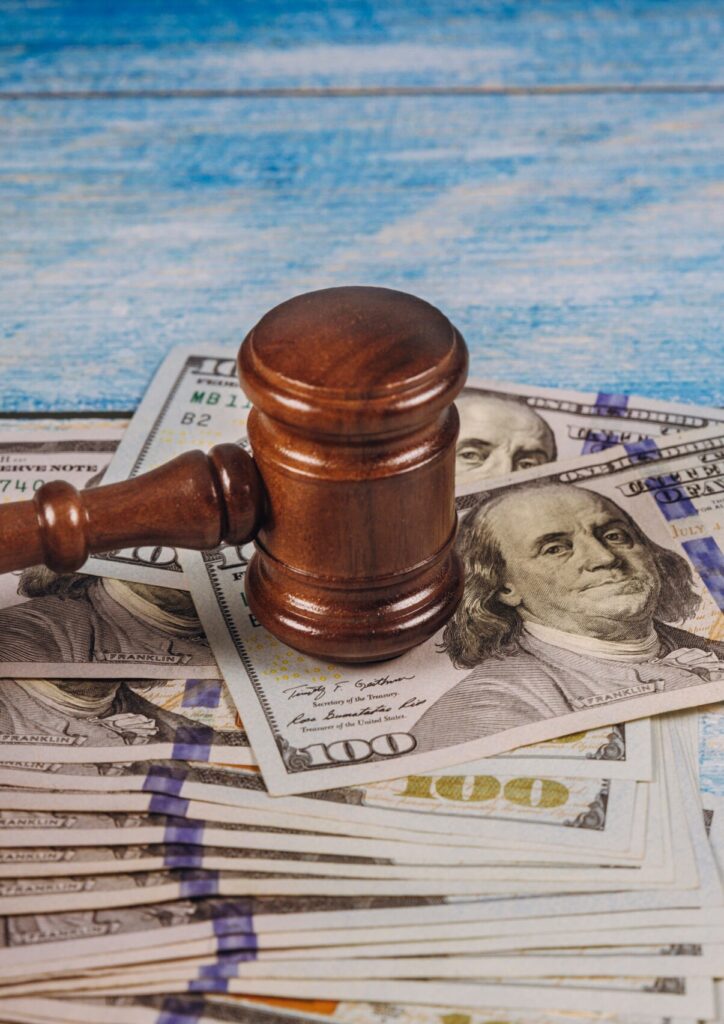 Judge’s gavel resting on U.S. dollar bills, representing bail money