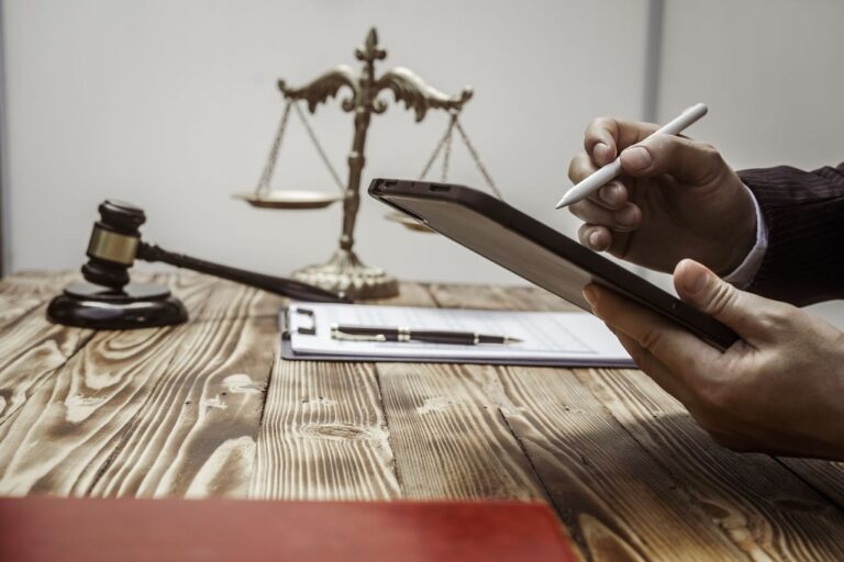 Gavel, scales of justice and a person reviewing bail paperwork